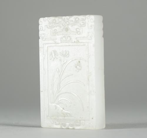 A Chinese white jade rectangular pendant, late 19th/20th century, one side carved in low relief with two insects and a flower, the reverse with three