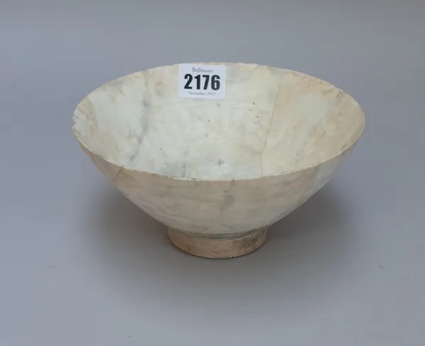 A Kashan white glazed pottery bowl, probably 12th century, raised on short foot, (a.f), 16.5cm. diameter.