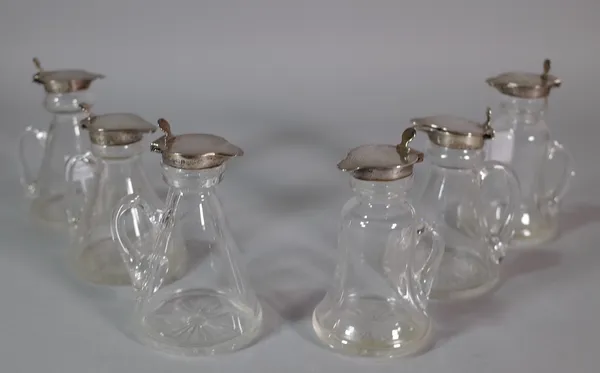 A matched set of six glass and silver topped small jugs, (6).