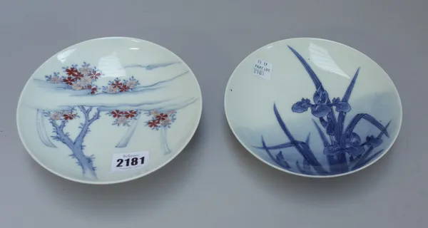 Two small Nabeshima dishes, Meiji period, each with a blue combed foot, one painted in underglaze-blue and red with flowering prunus branches amongst