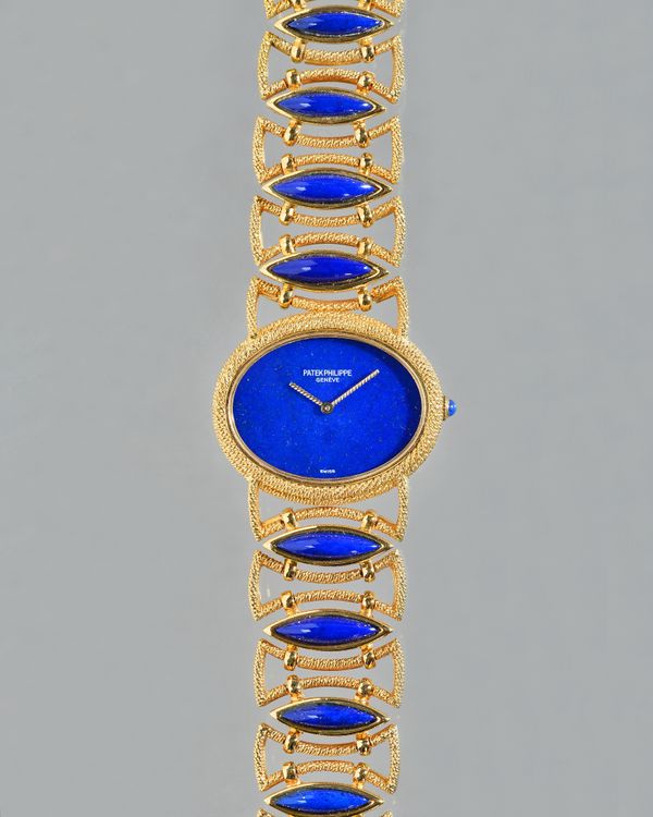 A Patek Philippe gold and lapis lazuli lady's dress bracelet wristwatch, the signed oval plain lapis lazuli dial with ropetwist hands, the ropetwist d