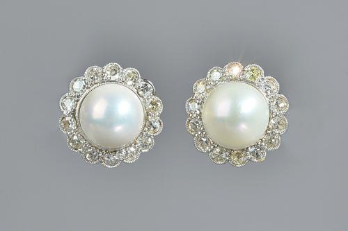 A pair of gold, diamond and cultured pearl cluster earstuds, each mounted with a cultured pearl at the centre, in a surround of circular cut diamonds,
