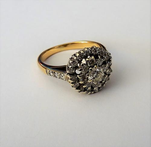 A gold and diamond set circular cluster ring, claw set with the principal circular cut diamond to the centre, in a surround of eight smaller circular