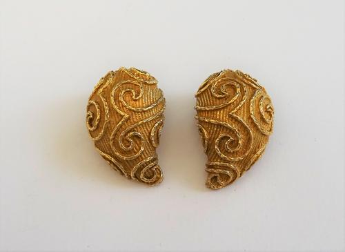 A pair of yellow precious metal earclips, of domed and reeded tear drop design, applied with scrolling wirework detailing, with clip fittings to the b