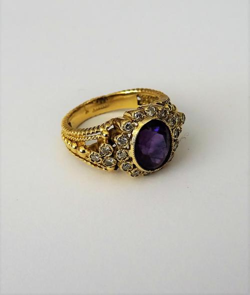 A gold, amethyst and diamond set oval cluster ring, mounted with the oval cut amethyst at the centre, in a surround of circular cut diamonds, between