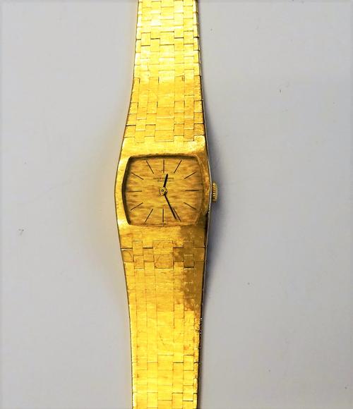 A lady's International Watch Company gold bracelet wristwatch, the signed textured gilt dial with black baton numerals and with black hands, on a tape