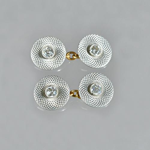 A pair of platinum and gold, diamond set dress cufflinks, with circular backs and fronts, each side collet set, with a cushion shaped diamond to the c