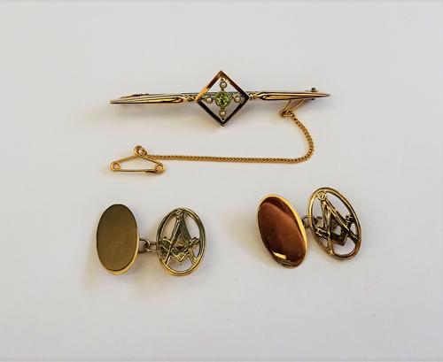 A pair of oval 9ct gold masonic cufflinks, the fronts pierced with square and compasses motifs and a gold, peridot and seed pearl set bar brooch, the