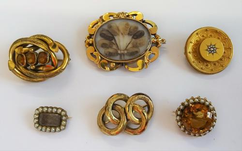 A gold brooch, claw set with a circular cut citrine to the centre, in a surround of cultured pearls, a small Georgian brooch, glazed with a woven hair