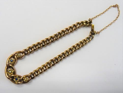 A gold, sapphire and half pearl set bracelet, in a hollow curb link design, on a snap clasp, detailed 9 CT, circa 1910, fitted with a safety chain, gr