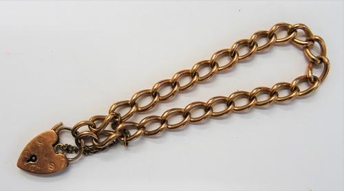 A 9ct gold curb link bracelet, on a 9ct gold heart shaped padlock clasp, Birmingham 1964, fitted with a safety chain, weight 22.4 gms.