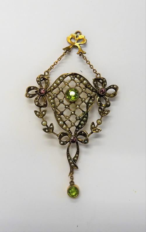 A gold, peridot, seed pearl and gem set pendant, in a lattice pierced wreath and bow design, collet set with the circular cut peridot at the centre, c
