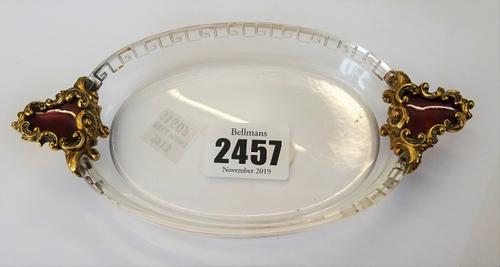 A gold, rose diamond set and red enamel mounted rock crystal oval twin handled trinket dish, the handles red enamelled to the centre, within rose diam