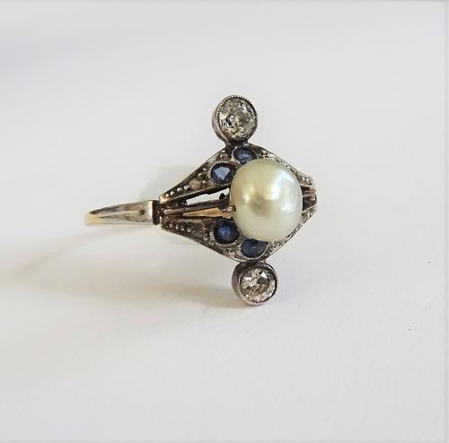 A diamond, natural salt water pearl and blue gem set ring, mounted with the natural salt water pearl to the centre and with two collet set principal c