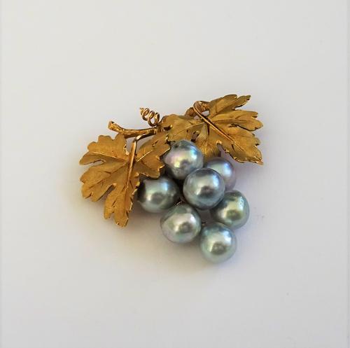 A cultured pearl brooch by Buccellati, designed as a bunch of grapes composed of seven baroque grey cultured pearls, suspended from two yellow preciou