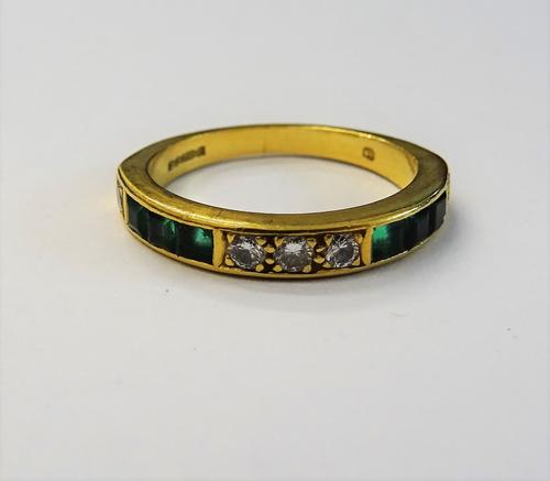 An 18ct gold, emerald and diamond half hoop ring, set with three circular cut diamonds, between calibre cut emeralds and diamonds, ring size K, gross