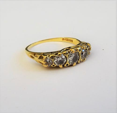 An 18ct gold and diamond five stone ring, mounted with a row of circular cut diamonds graduating in size to the centre stone, the mount decorated with