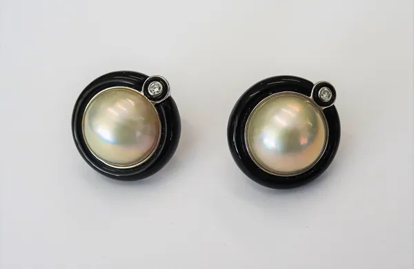 A pair of black jade, diamond and cultured pearl earclips, the mabé pearls collet set in a surround of carved black jade, above a central diamond, set