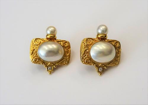 A pair of mabé pearl and diamond set yellow precious metal earclips of rectangular design, the central oval mabé pearls collet set in a mount, cast wi