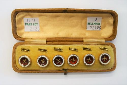 A set of six 9ct gold, red and white enamelled dress buttons, each of dished circular form, with wirework central motifs, on a red enamelled ground wi