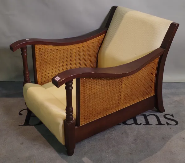 A 20th century hardwood low armchair with cane back.