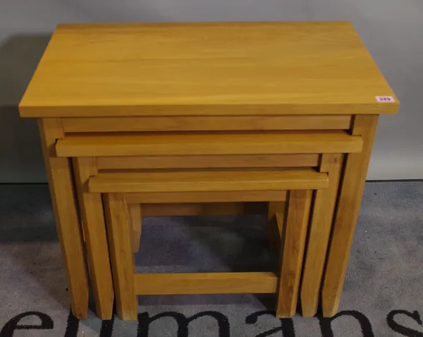 A modern oak nest of three tables, the largest 70cm wide x 60cm high.