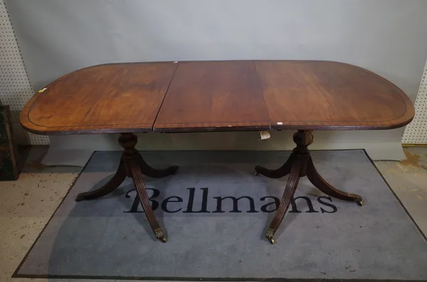 A Regency style inlaid mahogany extending dining table, one extra leaf, 92cm wide x 134cm long x 180cm extended.