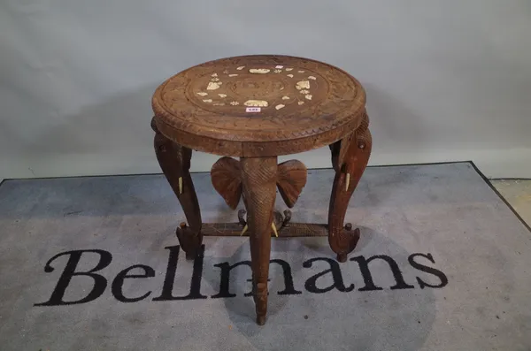 A mid-20th century Indian carved sandalwood occasional table, the bone inlaid under top on four carved elephant supports 54cm dia x 59cm high.