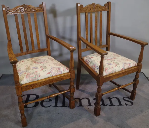 A pair of mid-20th century oak open armchairs with stick backs on block end turned supports, 57cm wide x 105cm high.