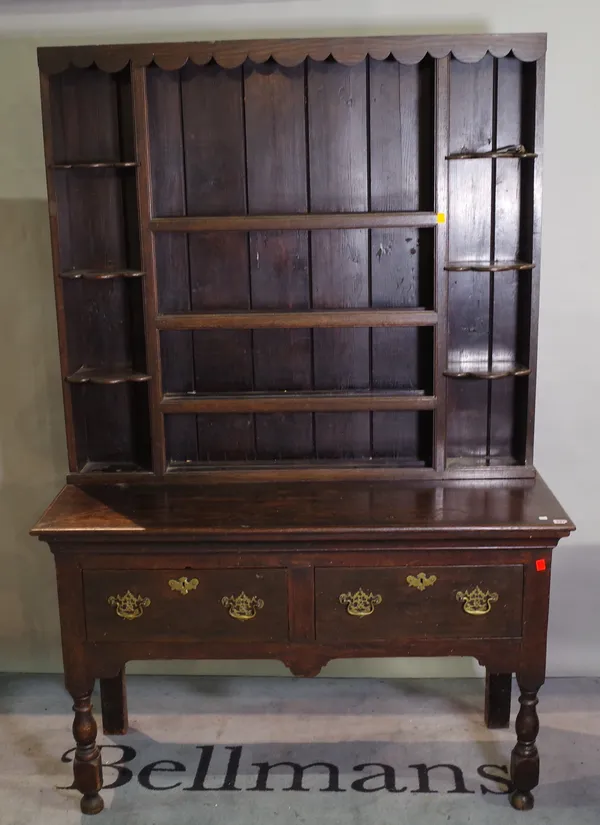 A late Victorian oak dresser with three tier plate rack over two drawers.