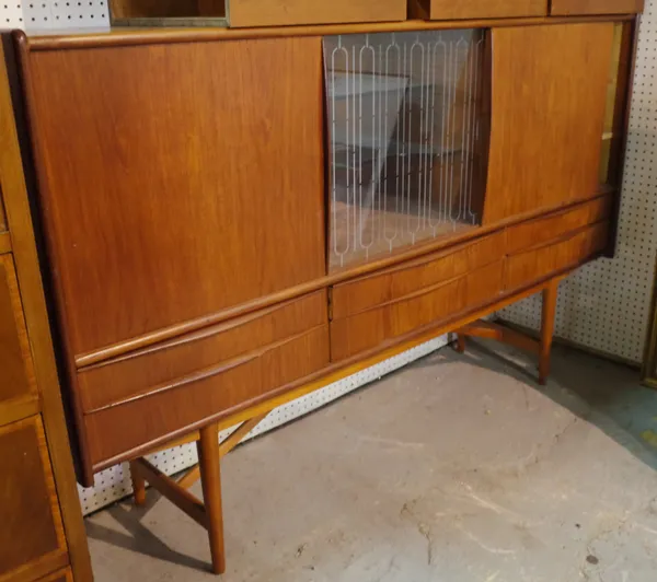 A mid 20th century Danish teak drinks cabinet with central glass section flanked by sliding doors on tapering supports 185cm wide x 117cm high x 44cm