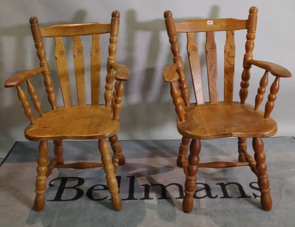 A set of six 20th century oak stick back dining chairs with carved floral motif on tapering turned supports, to include two carvers, 62cm wide x 97cm