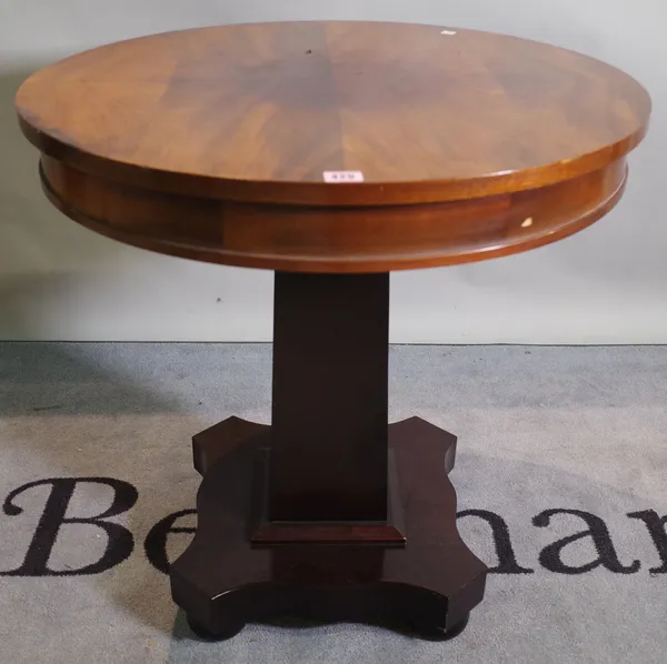 A 20th century mahogany circular centre table on ebonised tapering column on bun feet, 70cm dia x 71cm high.