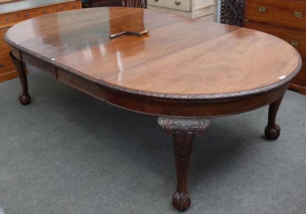 An early 20th century mahogany extending dining table on claw and ball feet, with two extra leaves, 144cm diameter x 252cm long extended.