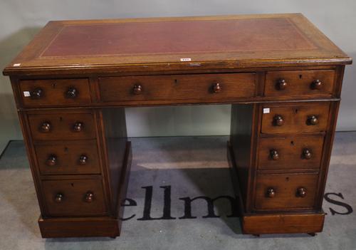 A late 19th century oak pedestal desk with nine drawers and red leather inset top, 108cm wide x 73cm high.