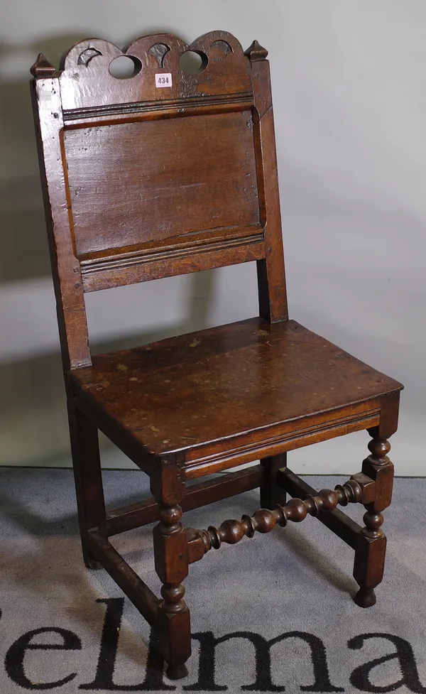 An 18th century and later oak continental chair, on block supports, united by turned stretcher, 48cm wide x 100cm high.