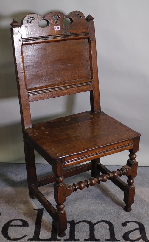 An 18th century and later oak continental chair, on block supports, united by turned stretcher, 48cm wide x 100cm high.