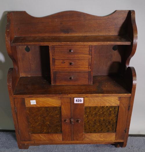 An early 20th century mahogany hanging cupboard, with three short drawers over orange coloured glass cupboard doors, 43cm wide x 61cm high.