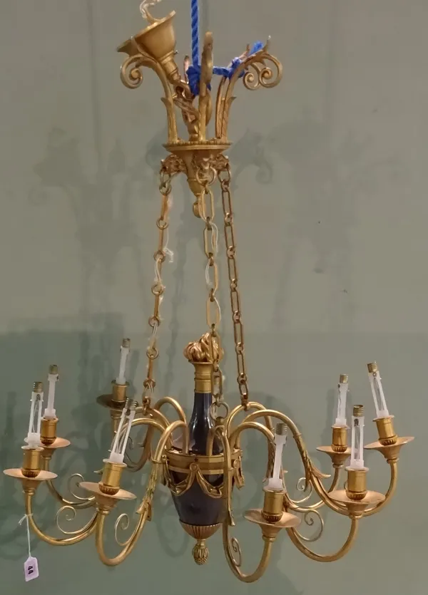 An ebonised and gilt brass Empire style nine branch chandelier, 20th century, the urn shaped body issuing nine swan neck branches, with an eagle cast