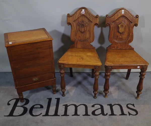 A pair of Victorian and later oak and elm shield back hall chairs, 42cm wide x 84cm high and a Victorian mahogany lift top side cupboard, 40cm wide x