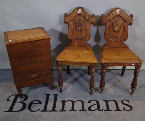 A pair of Victorian and later oak and elm shield back hall chairs, 42cm wide x 84cm high and a Victorian mahogany lift top side cupboard, 40cm wide x
