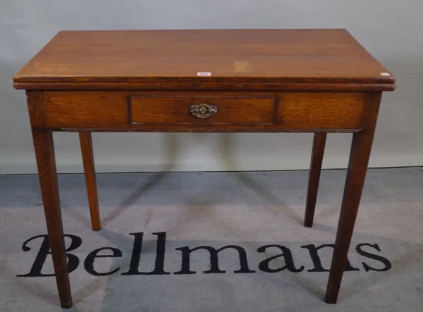 A 19th century oak foldover tea table with single drawer tapering square supports.