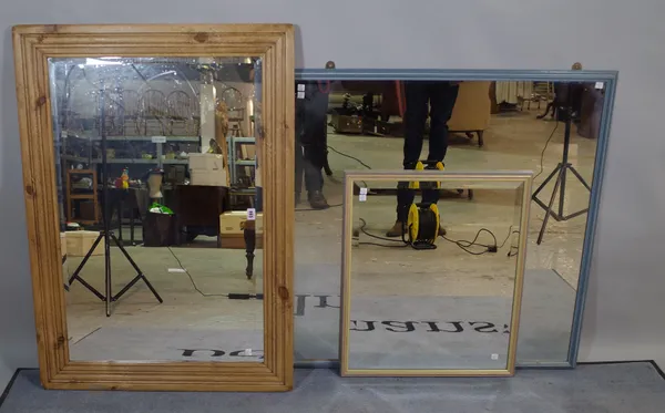 An early 20th century rectangular pine mirror with bevelled glass 78cm wide x 107cm high, a 20th century blue painted wall mirror 94cm wide x 94cm hig