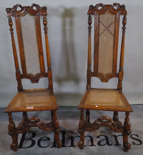 A pair of early 19th century continental stained beech high back chairs with cane seats, 45cm wide x 125cm high.