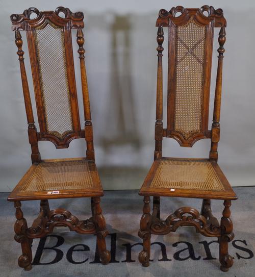 A pair of early 19th century continental stained beech high back chairs with cane seats, 45cm wide x 125cm high.