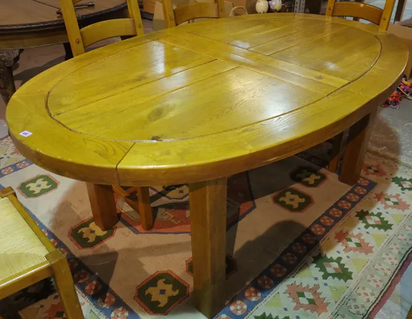 A 20th century oak oval extending dining table, 115cm wide x 185cm long x 265cm fully extended, on block supports, two extra leaves.