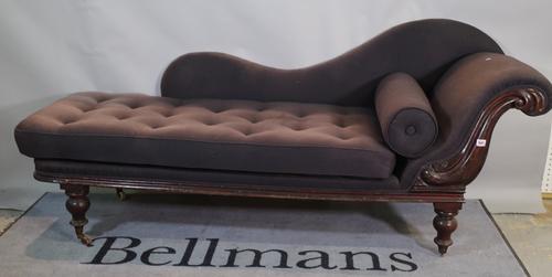 A Victorian mahogany purple upholstered chaise longue with shaped back and turned tapering supports, 198cm wide.