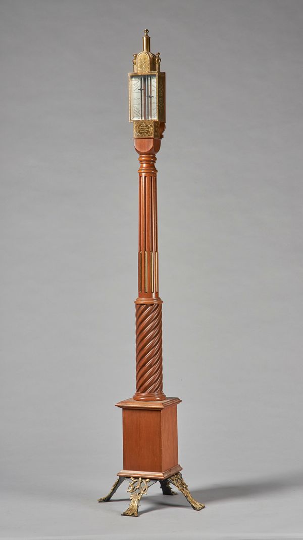 A giltmetal-mounted walnut portable standing barometerAfter the model by Daniel QuareThe top with gilt glazed hood and silvered scale, twin urn finial