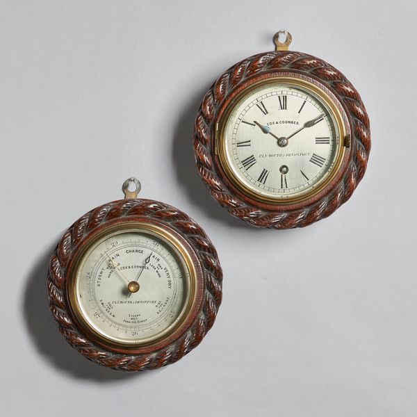 A circular oak rope-twist carved wall timepiece and ensuite aneroid barometerSigned Cox & Coombes, Plymouth & Devonport, circa 1895The timepiece with