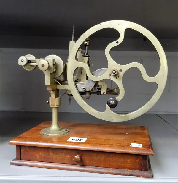 A nickel-plated watchmaker's wheel-cutting machine, with a rectangular wooden base, and fitted accessory drawer25cm wide